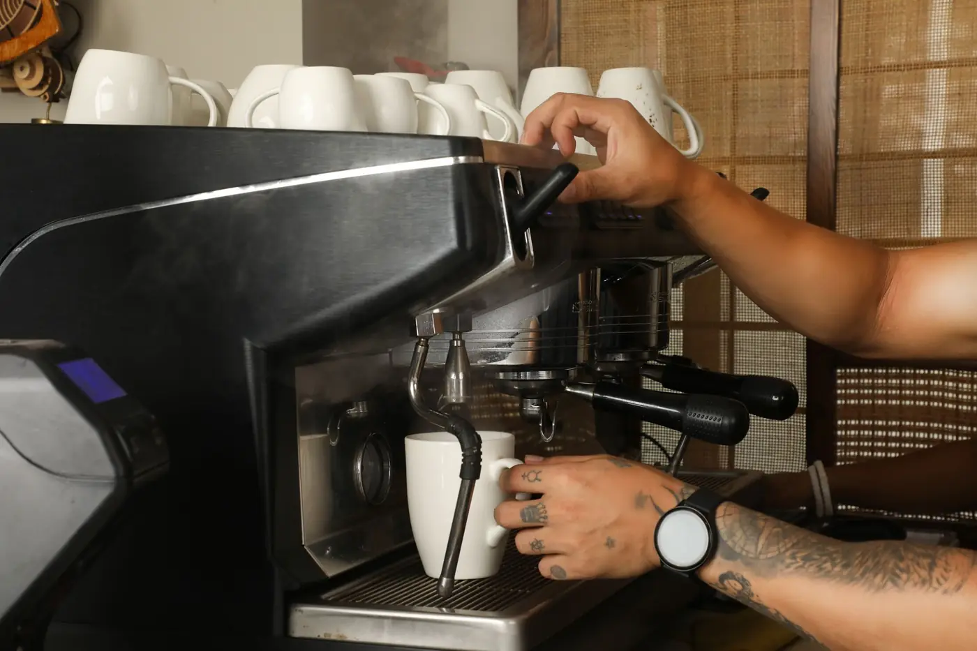 A barista pulling coffee at a cafe counter